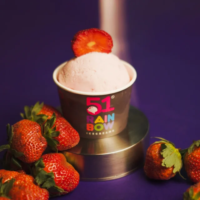 Delicious strawberry ice cream in a cup topped with fresh strawberries