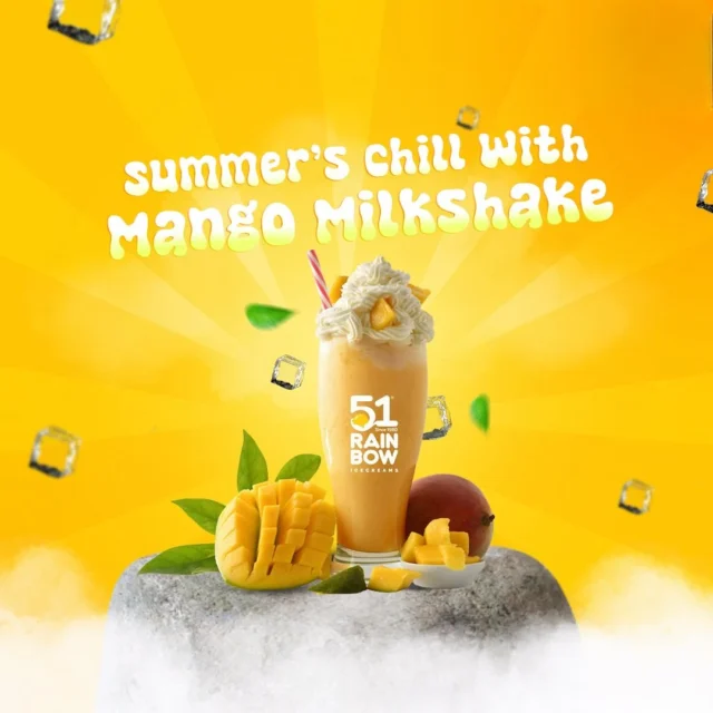 mango milkshake topped with whipped cream and fresh mango pieces